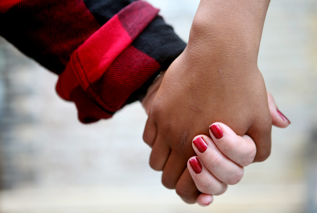 Two hands holding with red nail varnish