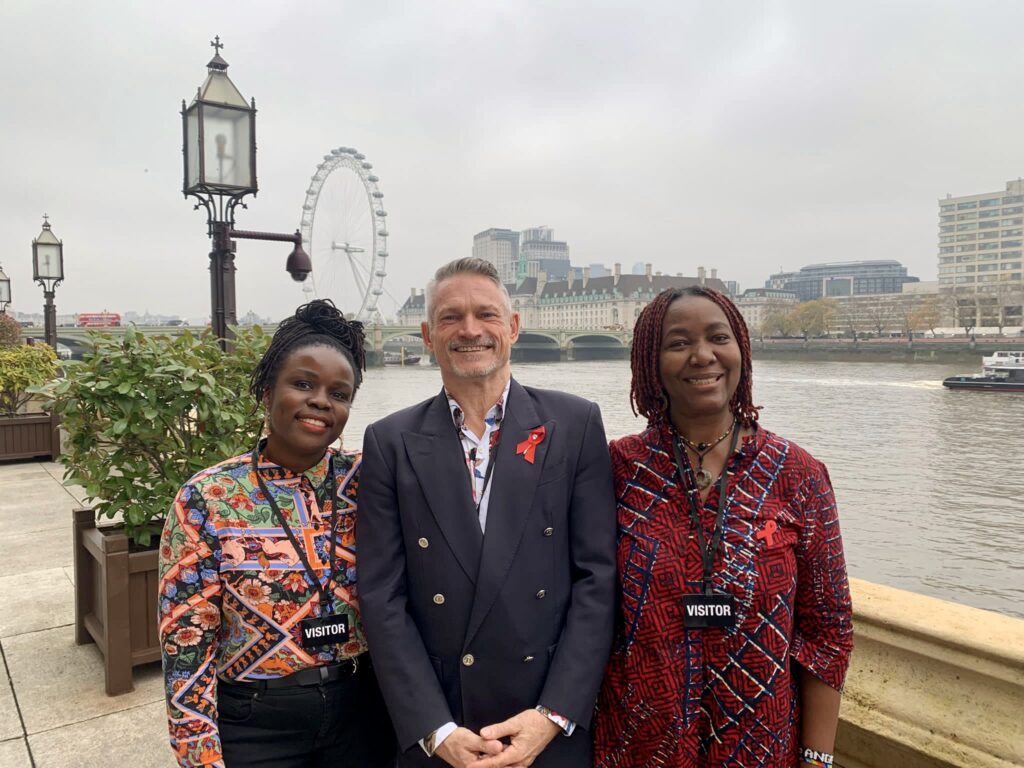 three people by houses of parliament